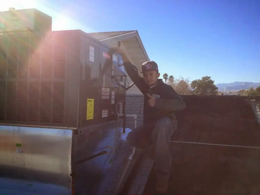 HVAC technician performing AC Tune-Up on a rooftop unit in Toledo